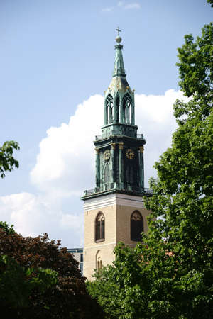 Berlin, Germany - May 10, 2016: The tower of the St. Mary's Church at Berlin Alexanderplatz square shines through trees on May 10, 2016 in Berlin.のeditorial素材