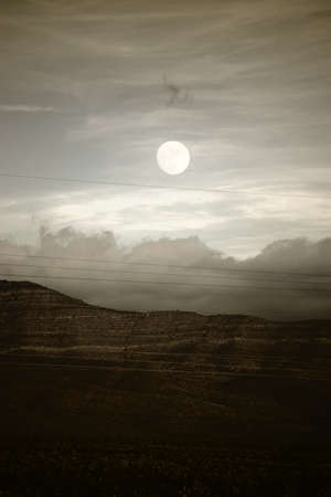 A cloud ribbon and the moon over the mountains between Amaragosa Valley and Las Vegas.の写真素材