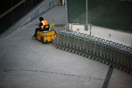 Los Angeles, United States - December 28, 2015: An airport staff member at LAX Airport is pulling a ramp up with a vehicle baggage car on December 28, 2015 in Los Angeles.のeditorial素材