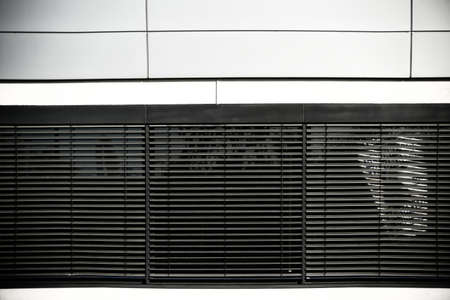 The facade of a modern office building with blinds in the windows.の写真素材