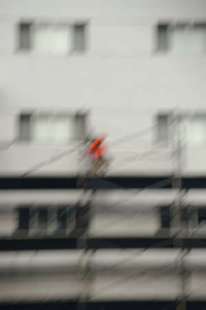The abstract blurred silhouette of a construction worker or scaffolding worker on a scaffolding.の写真素材