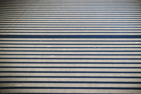 The close up of a walkway on a bridge whose railings throws symmetrical shadows.      
