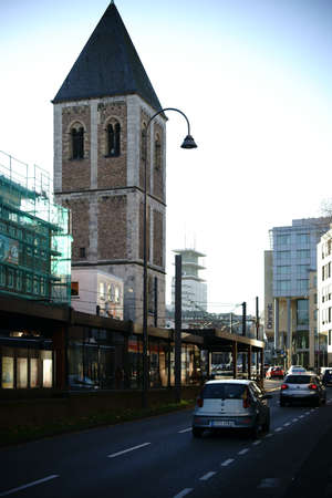 Cologne, Germany - November 24, 2016: Street traffic on the Pepin Street in front of the tower of the Little Saint Martin church in Cologne old town on November 24, 2016 in Cologne.のeditorial素材