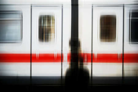The abstract blurred outer body of a passenger train with two windows and doors.                               の写真素材