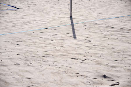 The marking of a beach volleyball field with tensioning cables in the sand beach and the post for the net.                       の写真素材