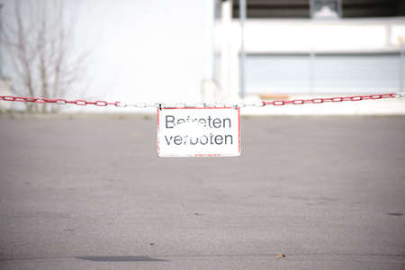 An old, rusty hanging sign on a chain with the inscription: entering forbidden.の写真素材
