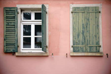 Old wooden and fading window shutters on a nostalgic window.                    の写真素材