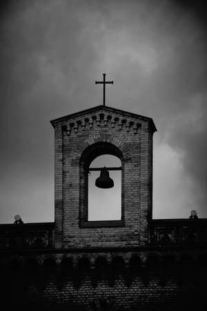 The bell tower of an old church with a hanging bell.の写真素材