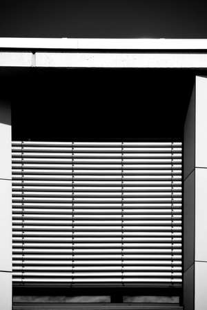 The modern facade of a modern residential building with a metal window with metal blinds.の写真素材
