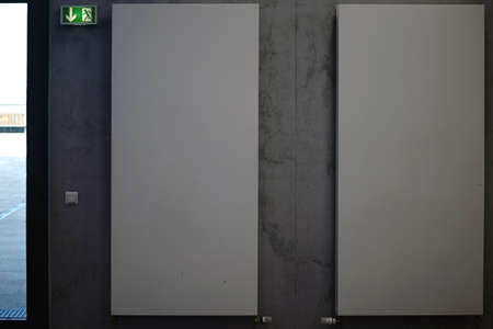 Two high wall radiators hanging on a striking concrete wall.