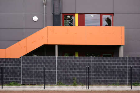 Detail of a modern exterior staircase in front of symmetrically arranged fences.のeditorial素材