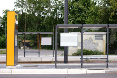 The newly build  glass shelter of a tram stop on a street.