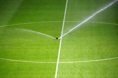 The green lawn surface of a soccer field with a irrigation system.                         の写真素材