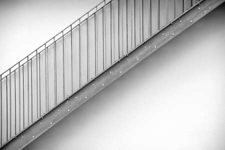 Detail of a modern exterior staircase in front of symmetrically arranged fences.の写真素材