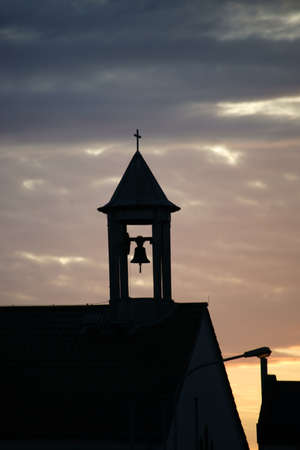 The bell tower of a church in the evening and sunset.の写真素材