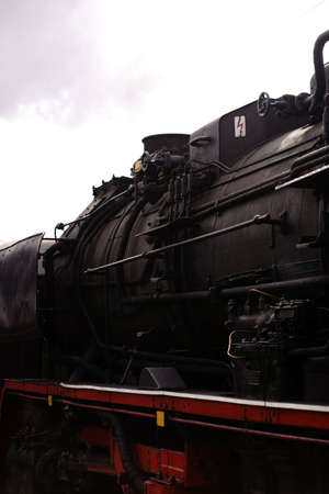 The side view of an old steam locomotive with coal for heating the steam boiler.                    ...