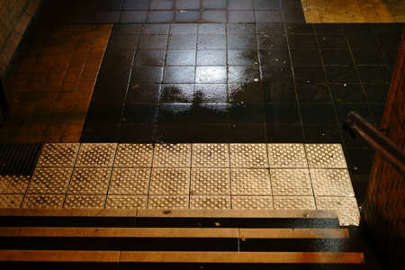 The dark steps of a station tunnel with puddles and damp walls.                            の写真素材