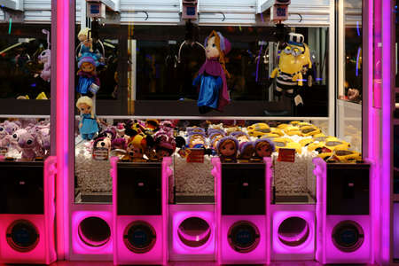 Berlin, Germany - December, 05, 2017: The close-up of dolls and stuffed animals of a colorfully lit doll-claw slot machine at a Christmas market on December 05, 2017 in Berlin.のeditorial素材