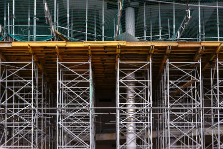 The close-up of a scaffolding with buttresses and safety nets.