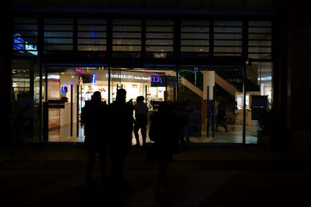 Berlin, Germany - December 05, 2017: The silhouettes of pedestrians and walkers in front of a department store in the night on the Berlin Alexanderplatz on December 05, 2017 in Berlin.のeditorial素材