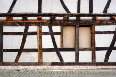 The beam construction and the timber frame of a half-timbered house with a nailed window.                 の写真素材