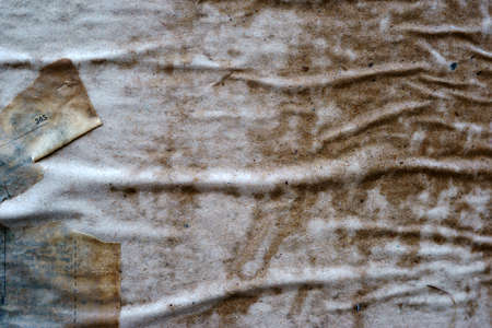 The close-up of a billboard with damp and soaked paper and scraps of paper from posters and billboards.                         の写真素材