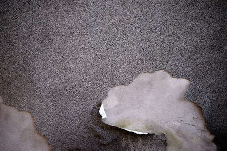 The close up of a facade with a chipped plaster layer.                        