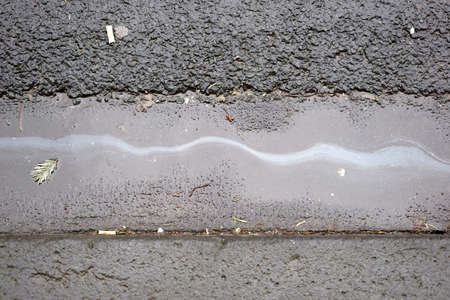 An oil film or oil trail on the wet asphalt of a road.                             の写真素材