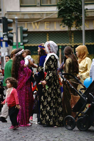 Mainz, Germany - September 25, 2015: Kurdish women holding colorful children's costumes at...