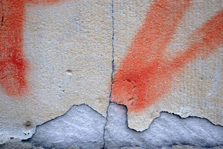 The close-up of a wall with a chipped and painted plaster layer.                              