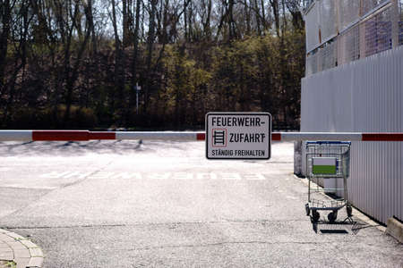 A closed barrier at the entrance to the backyards of a shopping center with fire service access.    ...