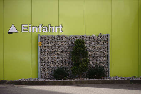 Stones in a display case made of metal mesh serve as decoration for a gate entrance.                              の写真素材