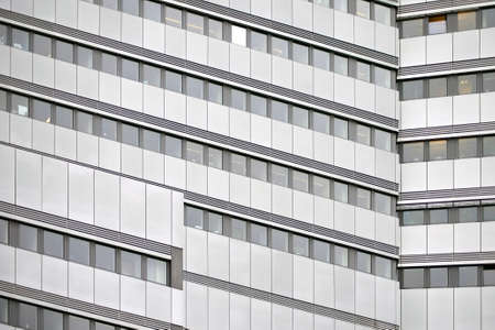 The modern facade of an office building with window rows.                     