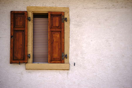 A residential building with a closed window with shutter.