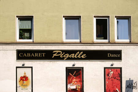 Munich, Germany - June 30, 2018: The facade of the cabaret and dance theater Pigalle with posters and photographs of lascivious women and the Moulin Rouge on June 30, 2018 in Munich.のeditorial素材