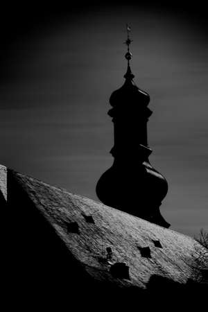The silhouette of a church tower in the incoming moonlight against a dark blurred background.のeditorial素材