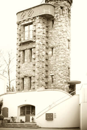 A tower-like residential building with an entrance and heavy stones.