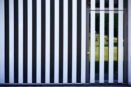 Modern house facade made of metal panels with a door.