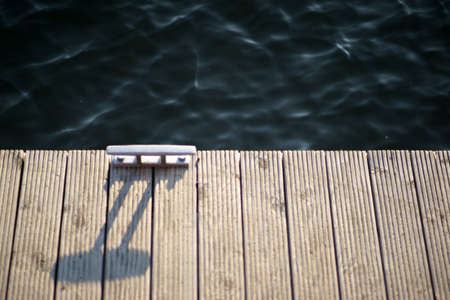 The close-up of the edge of a wooden walkway with a ship holder.の写真素材