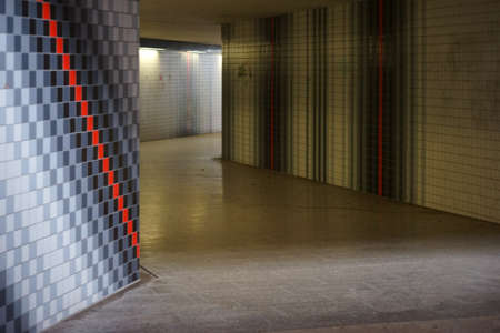 The underpass of a train station with modern patterned tiled walls.