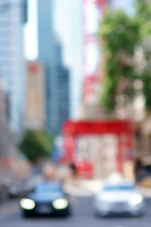 The abstract and blurred silhouettes of skyscrapers of a street canyon in Frankfurt with street traffic in the foreground.の写真素材