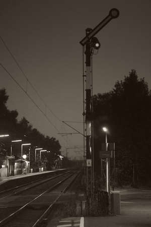 Railway tracks and train signals at night at the platform Eddersheim.の写真素材