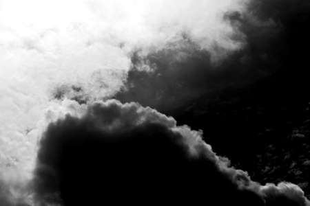 The abstract vortex of dark storm clouds with light breaks.