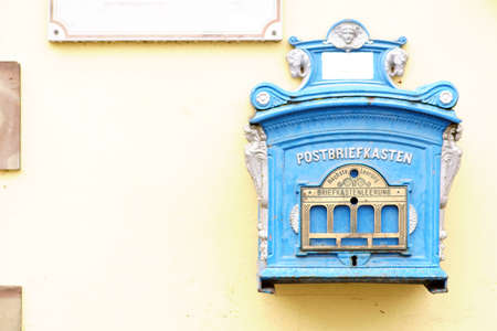 An old nostalgic mailbox on a yellow house wall.の写真素材
