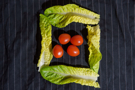 Washed cherry tomatoes and lettuce on dark blue towelの写真素材