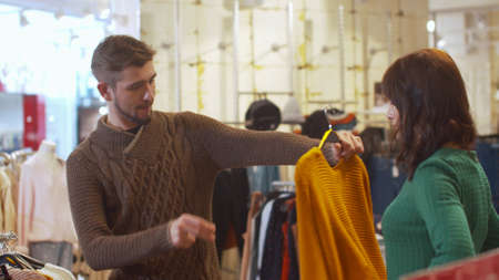 Young man chooses clothes for his woman