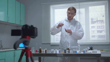 Man in protective workwear show his work on camera in the laboratoryの写真素材