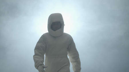 An cosmonaut in a spacesuit goes to the camera and smiles