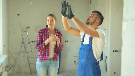 Builder shows a repair to a woman