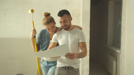 Man and woman look at scheme and talkの写真素材